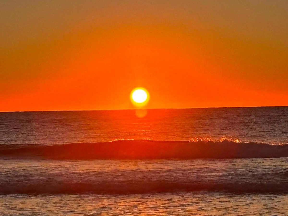 The sun rising over the sea, photographed at the shore
